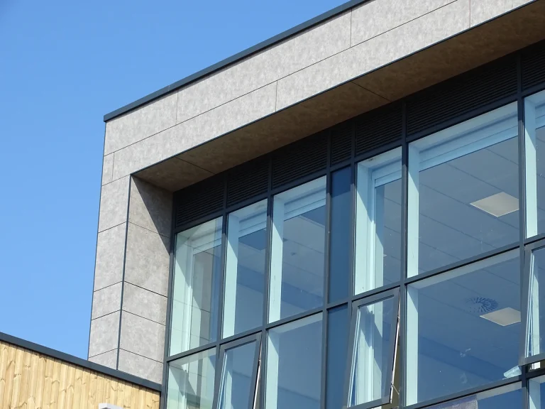 Modern building featuring a sleek rainscreen cladding system combined with large glazed windows, installed by S and G Industrial Roofing, enhancing both appearance and technical performance.